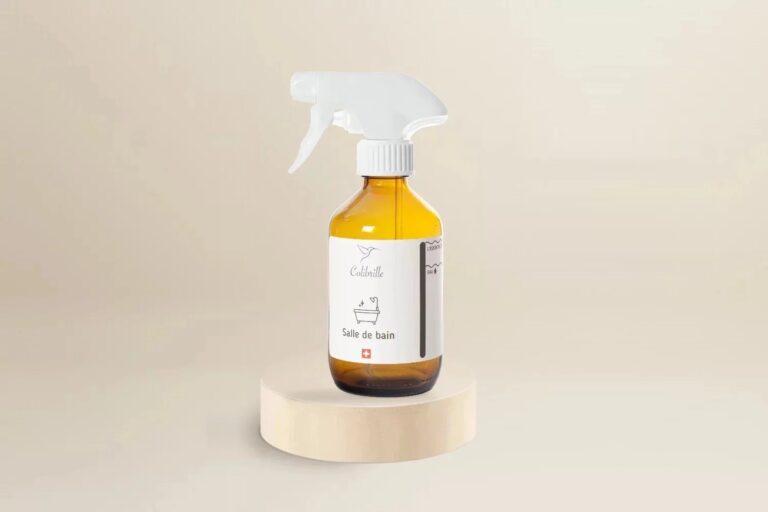 Bouteille en verre ambré vide Colibrille Salle de bains, avec étiquette, sur un socle en bois