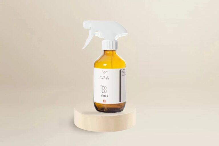 Bouteille en verre ambré vide Colibrille Vitres, avec étiquette, sur un socle en bois