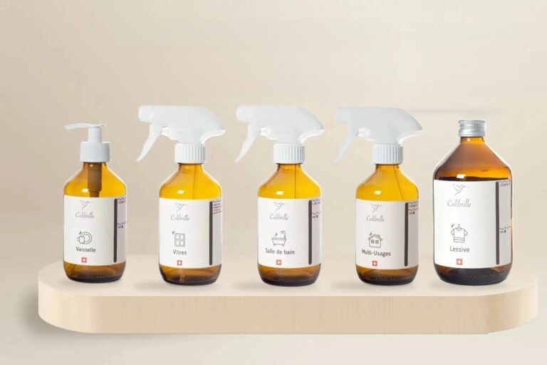 Lot des cinq bouteilles en verre ambré vides Colibrille sur un plateau en bois : vaisselle, vitres, salle de bains, multi-usages et lessive